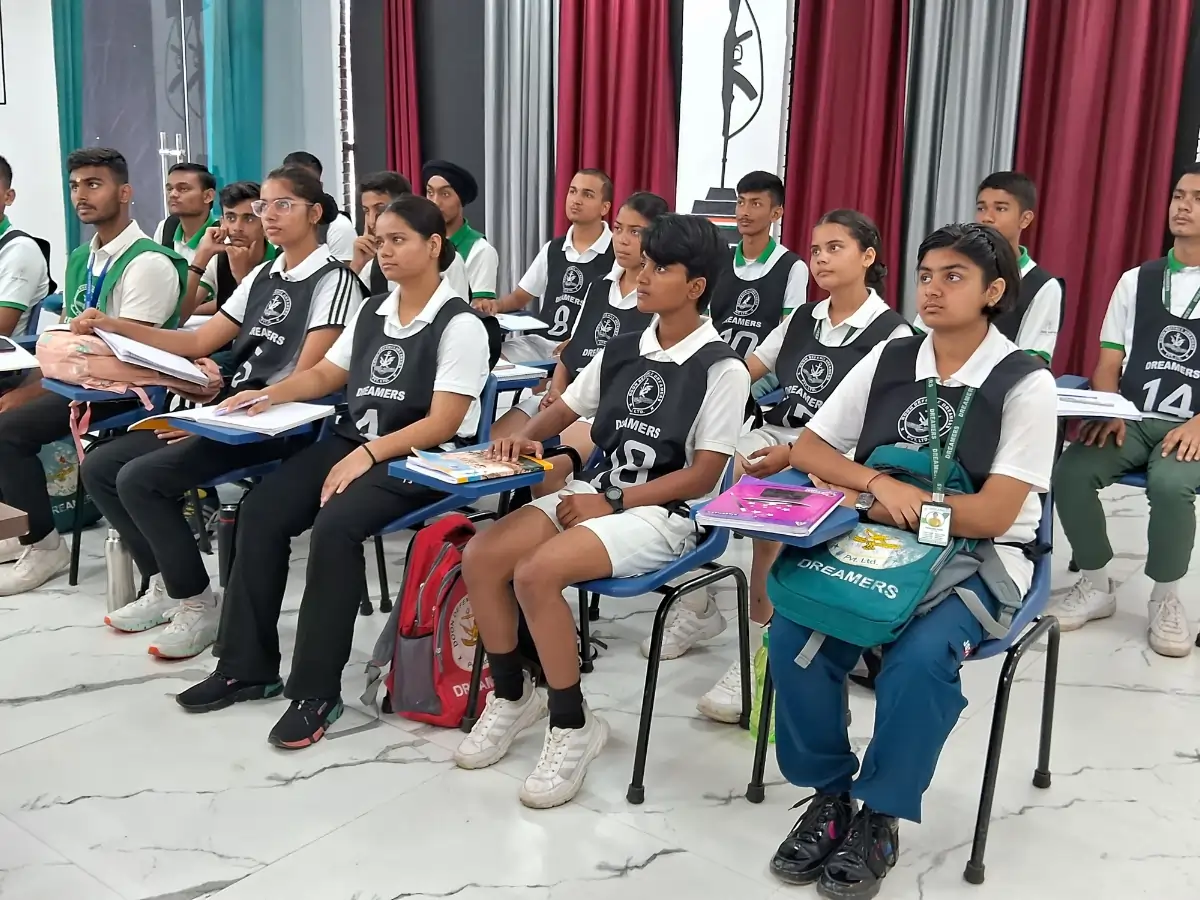 Best NDA Coaching Institute in Dehradun — Syllabus, Fees, Batches Students sitting in a classroom wearing Dreamers uniforms, listening attentively during a lesson.